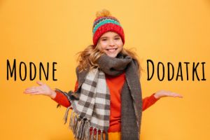 Happy girl in sweater, scarf and hat shrugs her shoulders